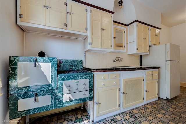 3916 51st St, Woodside, NY 11377 - kitchen featuring dark countertops, decorative backsplash, and freestanding refrigerator