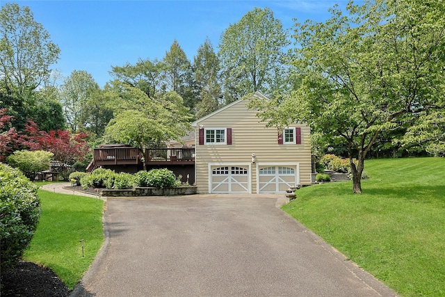 9 Van Houten Flds, West Nyack, NY 10994 - view of front of home featuring driveway, a deck, a garage, a front yard, and view of wooded area