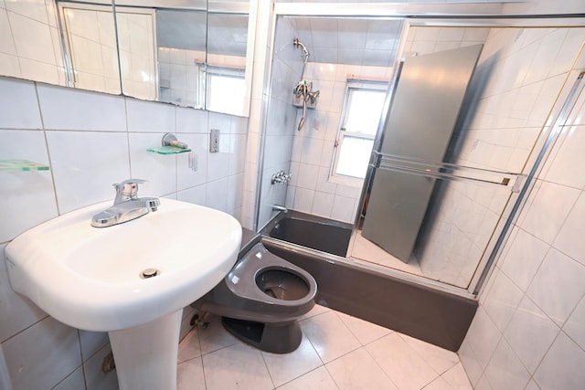 1078 Hancock Ave, Franklin Square, NY 11010 - bathroom featuring tile walls, plenty of natural light, shower / bath combination with glass door, and tile patterned flooring