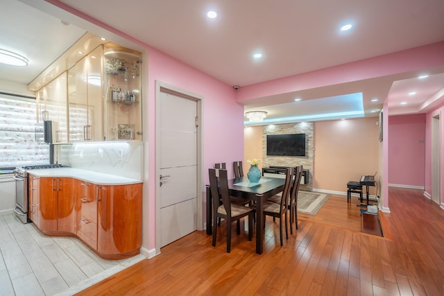 98-40 64th Ave Unit 1B, Rego Park, NY 11374 - dining space with light wood finished floors, a fireplace, bar with sink, and recessed lighting