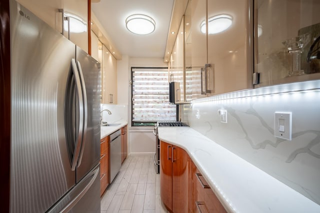 98-40 64th Ave Unit 1B, Rego Park, NY 11374 - kitchen featuring appliances with stainless steel finishes, brown cabinets, modern cabinets, and light stone counters