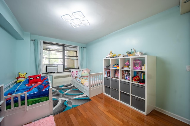 98-40 64th Ave Unit 1B, Rego Park, NY 11374 - bedroom featuring radiator, wood finished floors, and cooling unit