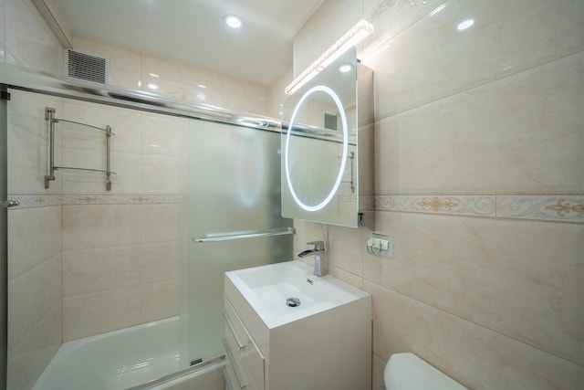 98-40 64th Ave Unit 1B, Rego Park, NY 11374 - bathroom with vanity, shower / bath combination with glass door, recessed lighting, and tile walls