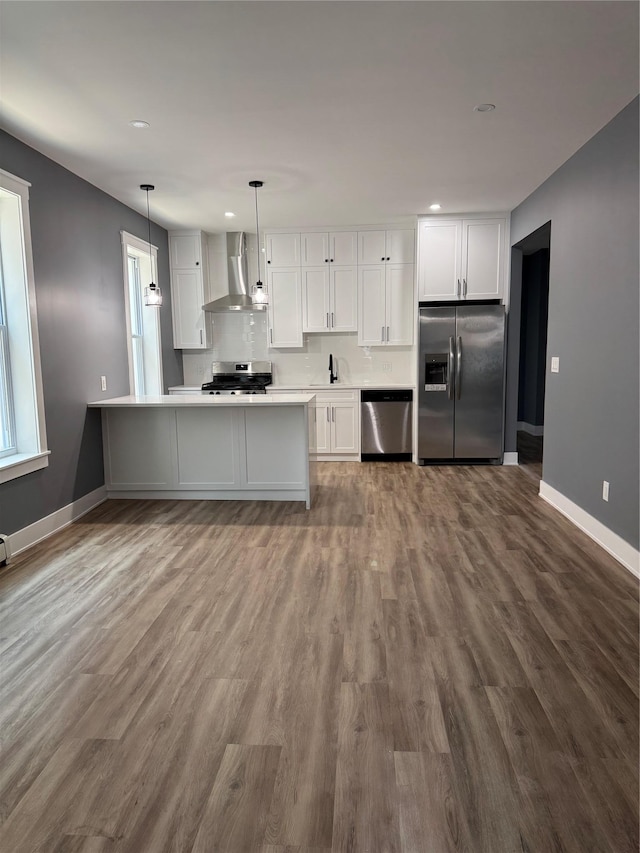 1140 Sutter Ave, Brooklyn, NY 11208 - kitchen with stainless steel appliances, wall chimney range hood, white cabinetry, light countertops, and dark wood-style floors