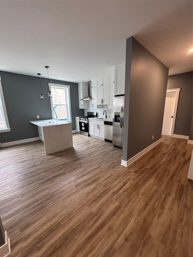 1140 Sutter Ave, Brooklyn, NY 11208 - kitchen featuring appliances with stainless steel finishes, wall chimney exhaust hood, wood finished floors, and white cabinets