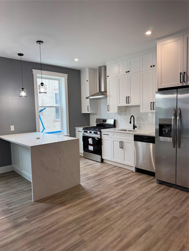 1140 Sutter Ave, Brooklyn, NY 11208 - kitchen featuring stainless steel appliances, wall chimney range hood, light wood-type flooring, white cabinetry, and recessed lighting
