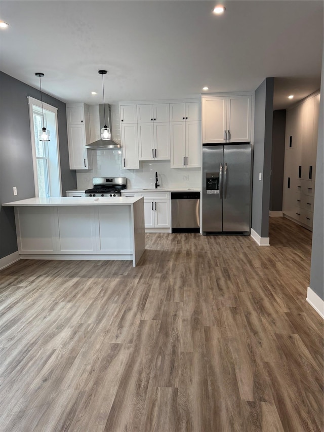 1140 Sutter Ave, Brooklyn, NY 11208 - kitchen with stainless steel appliances, wall chimney range hood, recessed lighting, white cabinetry, and light countertops