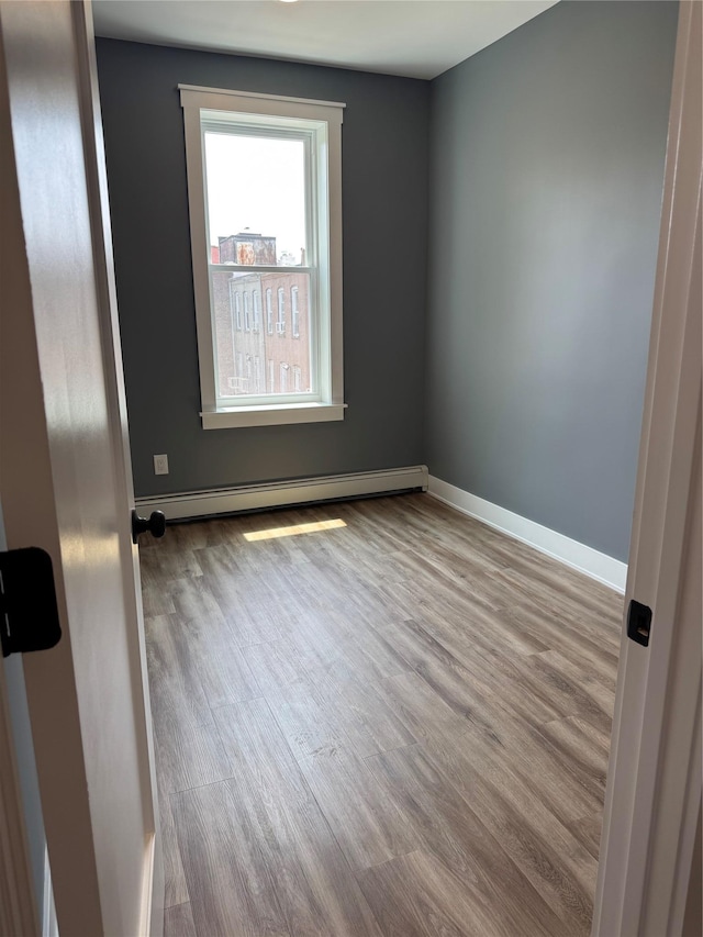 1140 Sutter Ave, Brooklyn, NY 11208 - empty room featuring wood finished floors and a baseboard heating unit