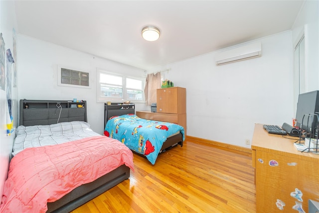 67-15 214th St, Bayside, NY 11364 - bedroom with a wall mounted air conditioner and light wood-style floors
