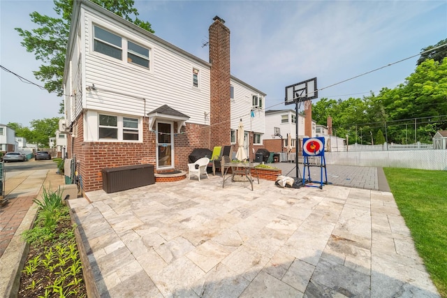 67-15 214th St, Bayside, NY 11364 - rear view of property featuring brick siding, a chimney, and a patio