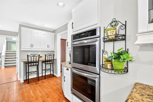 4 S Hill Rd, Tomkins Cove, NY 10986 - kitchen featuring double oven, white cabinetry, light wood finished floors, recessed lighting, and light stone counters