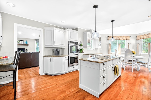 4 S Hill Rd, Tomkins Cove, NY 10986 - kitchen with double oven, light wood finished floors, white cabinetry, black electric cooktop, and light stone counters
