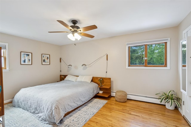 7 Nantucket Ln, Deer Park, NY 11729 - bedroom featuring baseboard heating, light wood-style flooring, and a ceiling fan