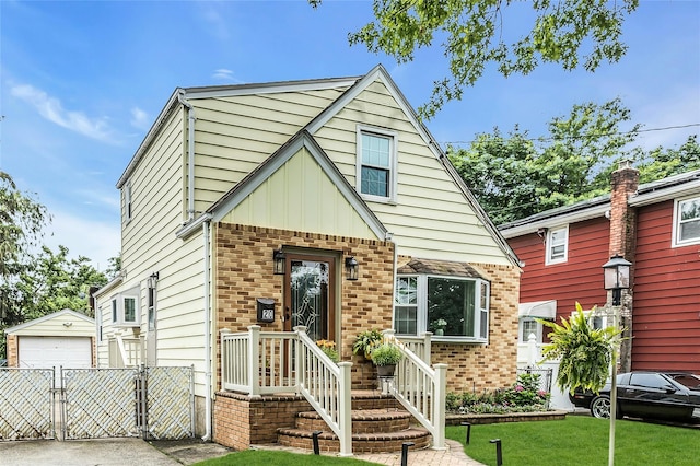 20 Spring Garden St, Valley Stream, NY 11580 - tudor-style house with a detached garage, an outdoor structure, brick siding, a gate, and concrete driveway