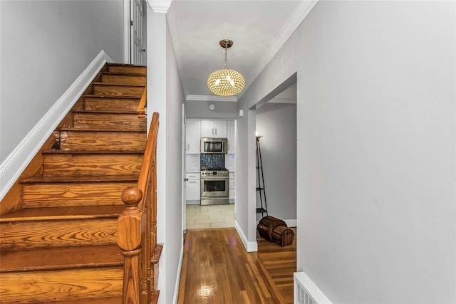 20 Spring Garden St, Valley Stream, NY 11580 - stairway with ornamental molding, wood finished floors, and a chandelier