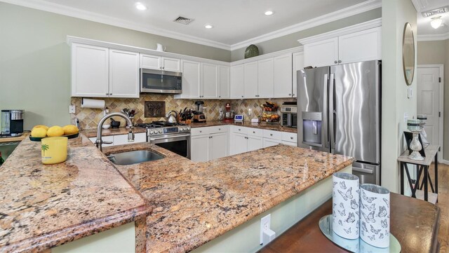 35 Terrace Ln Unit 35, Patchogue, NY 11772 - kitchen featuring stainless steel appliances, light stone counters, white cabinetry, recessed lighting, and tasteful backsplash