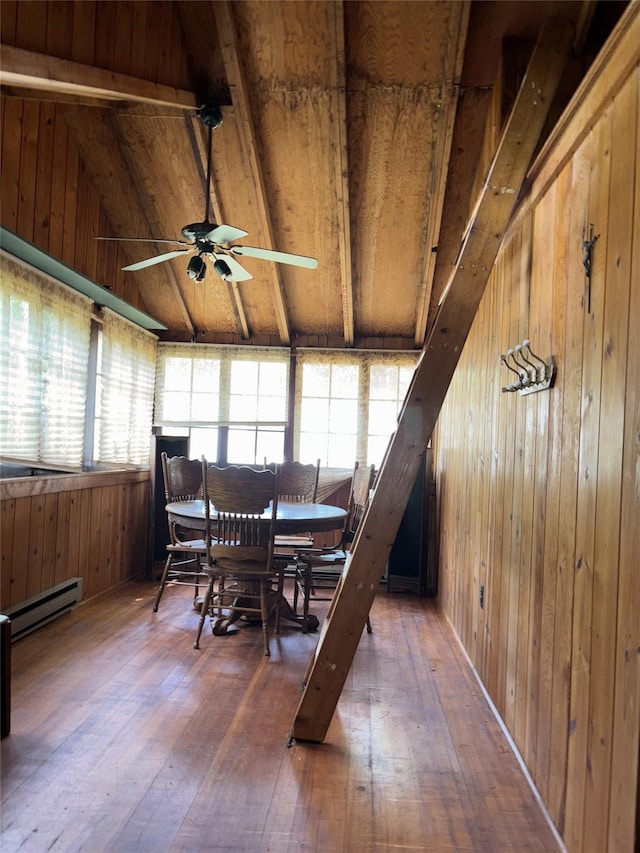 26 E Tusten, Smallwood, NY 12778 - dining space featuring baseboard heating, vaulted ceiling, wood walls, ceiling fan, and hardwood / wood-style flooring