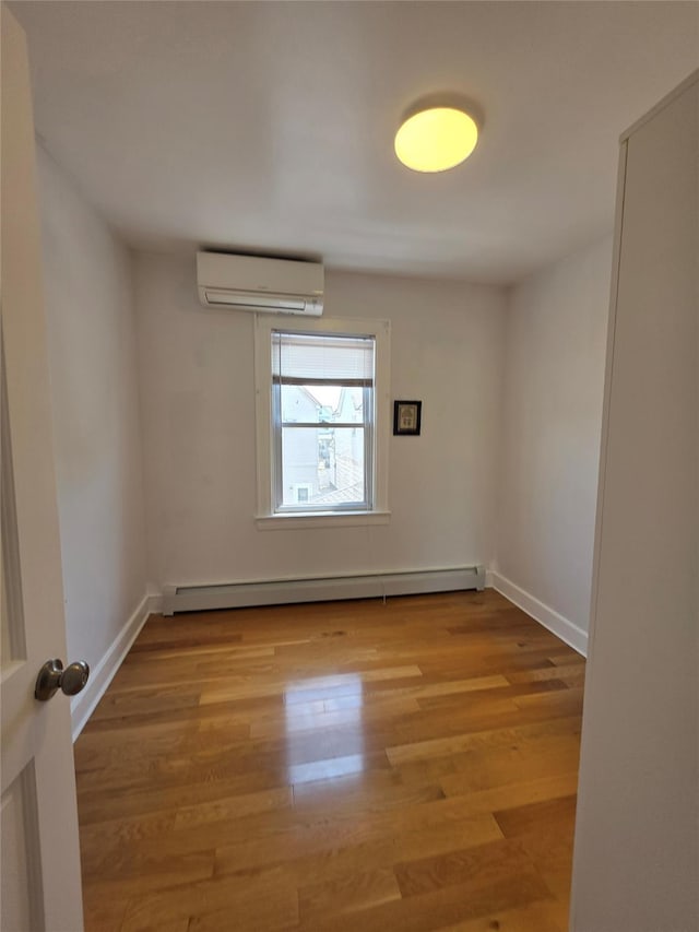 244-59 89th Ave, Bellerose, NY 11426 - unfurnished room with a wall unit AC, wood finished floors, and a baseboard radiator