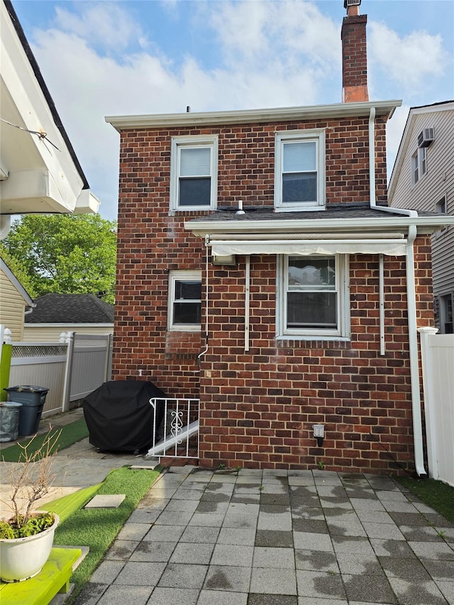 244-59 89th Ave, Bellerose, NY 11426 - rear view of property with brick siding, a chimney, and a patio