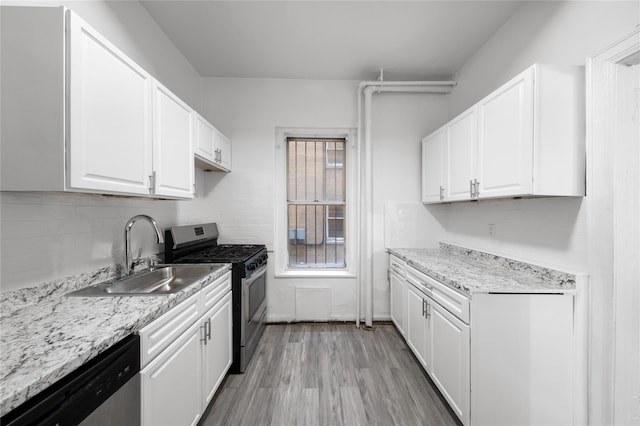 416 Ocean Ave Unit 15, Brooklyn, NY 11226 - kitchen featuring appliances with stainless steel finishes, white cabinetry, light wood finished floors, and tasteful backsplash