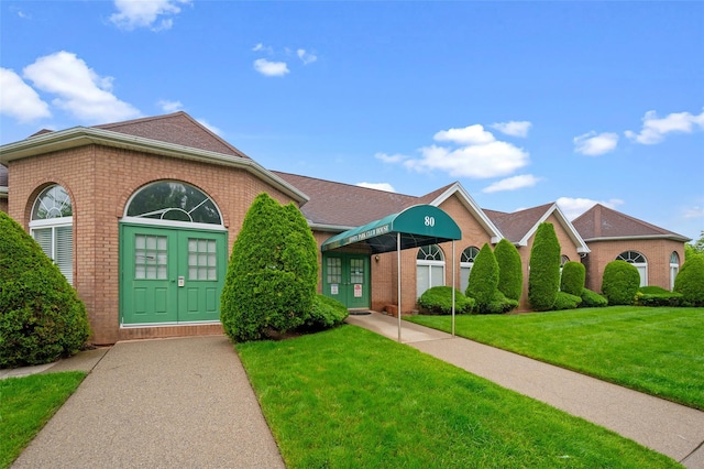 41 Wellington Ct Unit 1L, Staten Island, NY 10314 - view of front facade with french doors, brick siding, and a front yard