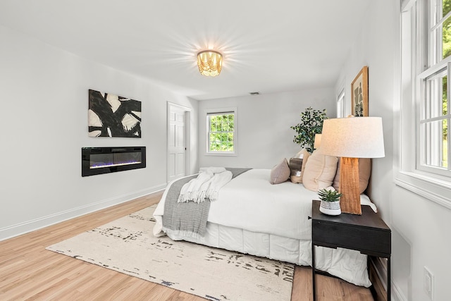 2022 Van Cortlandt Cir, Yorktown Heights, NY 10598 - bedroom featuring wood finished floors and a glass covered fireplace