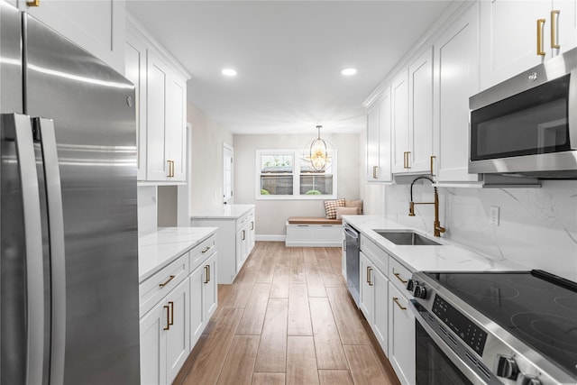 105 Julbet Dr, Sayville, NY 11782 - kitchen with appliances with stainless steel finishes, recessed lighting, white cabinets, light wood-style flooring, and light stone countertops