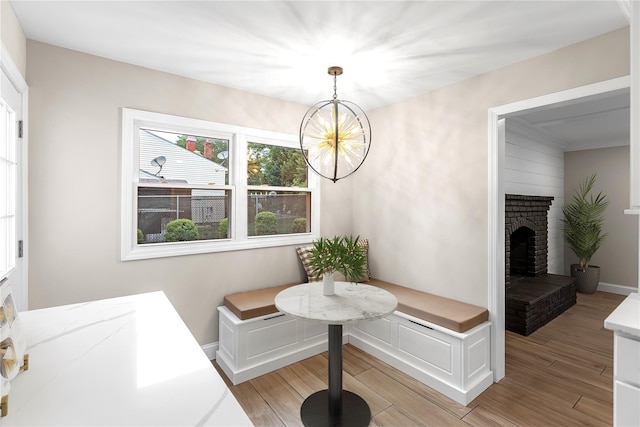105 Julbet Dr, Sayville, NY 11782 - dining room featuring light wood-style flooring, a chandelier, and a fireplace