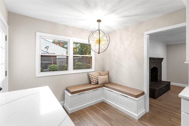 105 Julbet Dr, Sayville, NY 11782 - unfurnished dining area featuring light wood-style flooring, a chandelier, and a brick fireplace