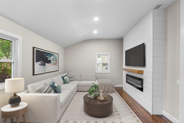 105 Julbet Dr, Sayville, NY 11782 - living area featuring dark wood-type flooring, recessed lighting, vaulted ceiling, and a fireplace