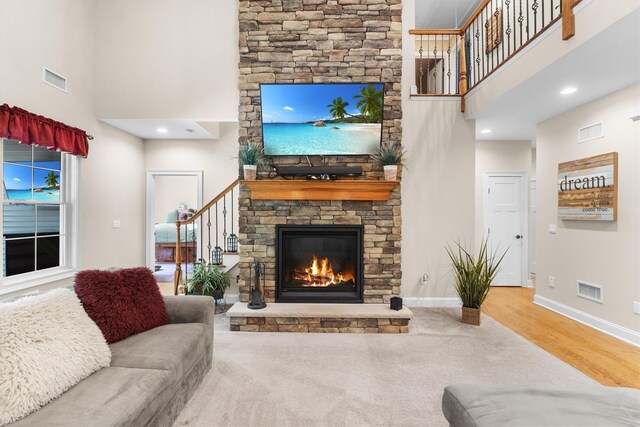 1 Hidden Hills Ct, Warwick, NY 10990 - carpeted living room featuring a towering ceiling, stairway, a stone fireplace, and wood finished floors