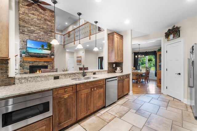 1 Hidden Hills Ct, Warwick, NY 10990 - kitchen with stainless steel appliances, a ceiling fan, light stone counters, pendant lighting, and a fireplace