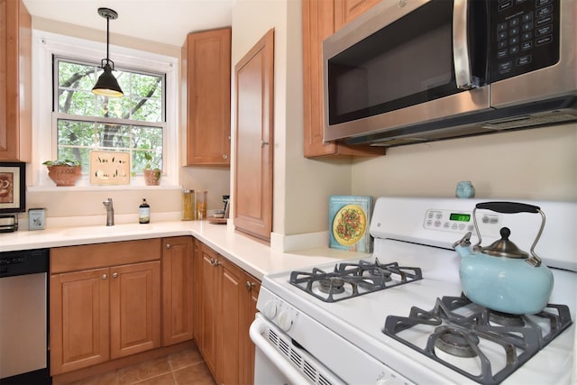 1360 Midland Ave Unit 1B, Bronxville, NY 10708 - kitchen with stainless steel appliances, light countertops, hanging light fixtures, and light tile patterned floors