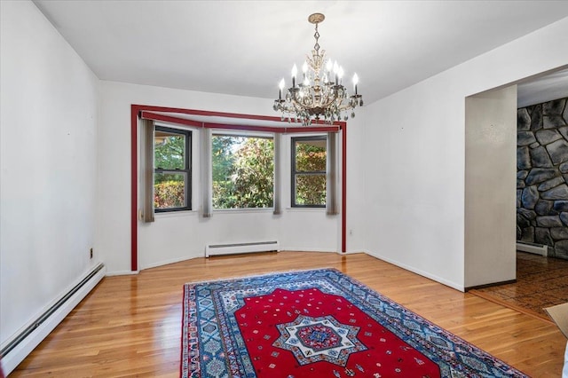175 Laurel Ln, Laurel Hollow, NY 11791 - unfurnished room with a baseboard heating unit, wood finished floors, and a chandelier