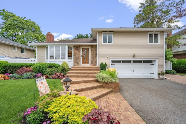 86 Phipps Ln, Plainview, NY 11803 - split level home with an attached garage, a chimney, asphalt driveway, a front lawn, and entry steps