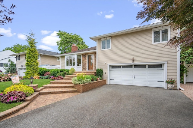 86 Phipps Ln, Plainview, NY 11803 - split level home featuring an attached garage, driveway, and a chimney