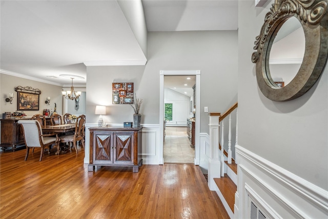 86 Phipps Ln, Plainview, NY 11803 - entrance foyer featuring hardwood / wood-style floors, a chandelier, wainscoting, crown molding, and a decorative wall