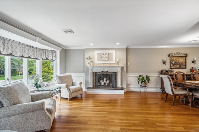 86 Phipps Ln, Plainview, NY 11803 - living area featuring ornamental molding, wood finished floors, a fireplace with raised hearth, recessed lighting, and a wainscoted wall