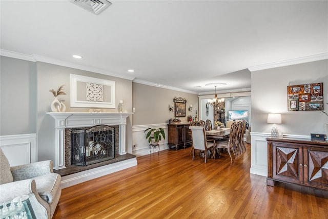 86 Phipps Ln, Plainview, NY 11803 - living area with wood finished floors, crown molding, a chandelier, recessed lighting, and a fireplace with raised hearth