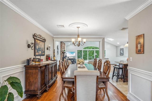86 Phipps Ln, Plainview, NY 11803 - dining area featuring a decorative wall, light wood-style flooring, a chandelier, ornamental molding, and a wainscoted wall