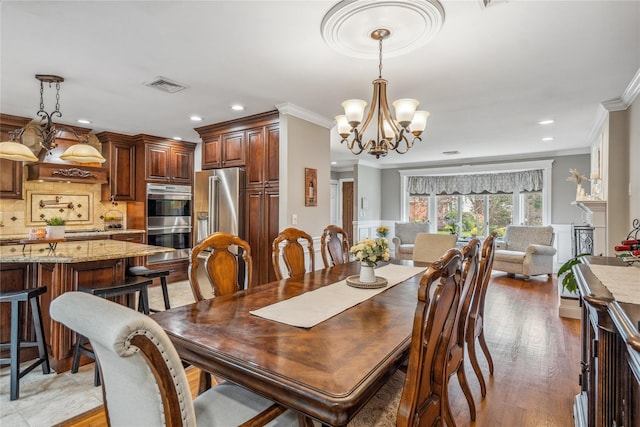 86 Phipps Ln, Plainview, NY 11803 - dining room with a chandelier, crown molding, recessed lighting, a wainscoted wall, and light wood-style flooring