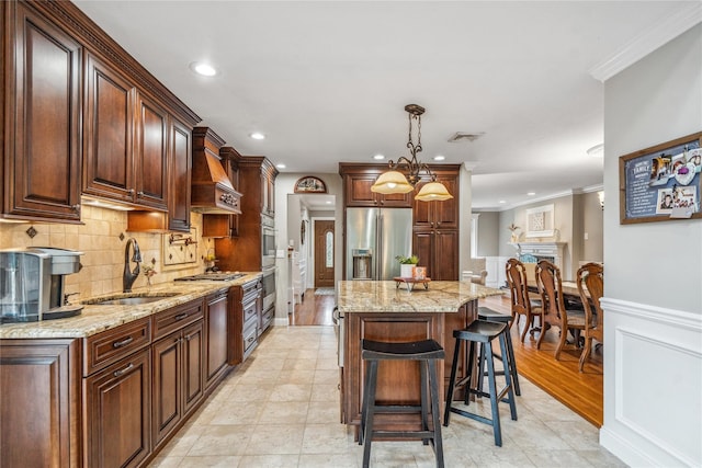 86 Phipps Ln, Plainview, NY 11803 - kitchen featuring stainless steel appliances, custom range hood, crown molding, a center island, and a kitchen breakfast bar