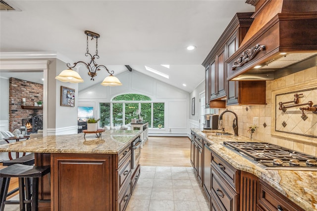 86 Phipps Ln, Plainview, NY 11803 - kitchen featuring stainless steel gas stovetop, a skylight, light stone countertops, a decorative wall, and vaulted ceiling