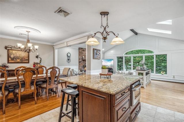 86 Phipps Ln, Plainview, NY 11803 - kitchen featuring a baseboard heating unit, light stone countertops, a decorative wall, a chandelier, and decorative light fixtures