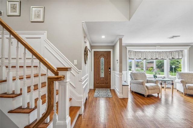 86 Phipps Ln, Plainview, NY 11803 - entryway with a decorative wall, ornamental molding, light wood-type flooring, stairs, and a wainscoted wall