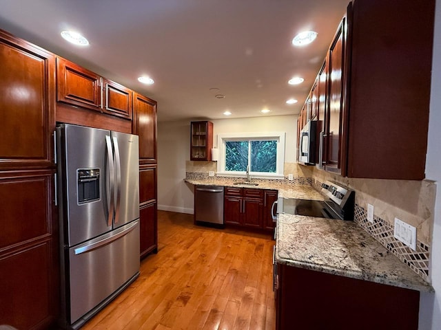 19 Harper Ave, Montrose, NY 10548 - kitchen with appliances with stainless steel finishes, tasteful backsplash, light wood-style floors, light stone countertops, and glass insert cabinets