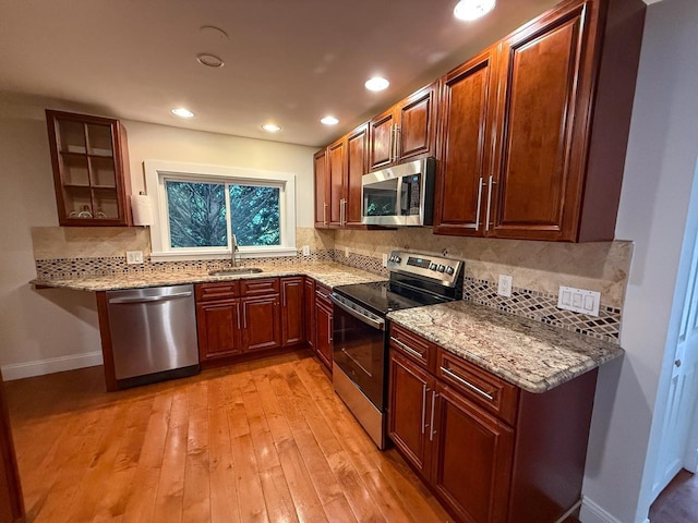 19 Harper Ave, Montrose, NY 10548 - kitchen with appliances with stainless steel finishes, light stone counters, light wood-type flooring, backsplash, and recessed lighting