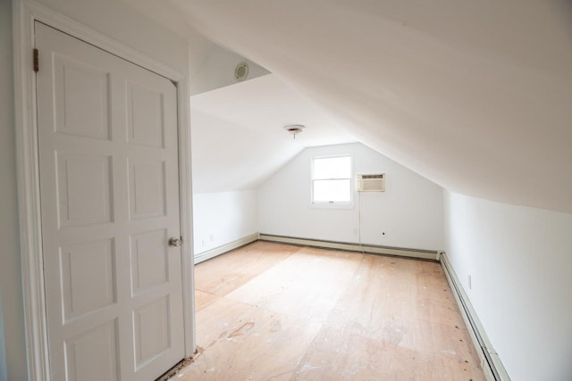 19 Harper Ave, Montrose, NY 10548 - additional living space with a baseboard heating unit, vaulted ceiling, baseboard heating, a wall unit AC, and light wood-style floors