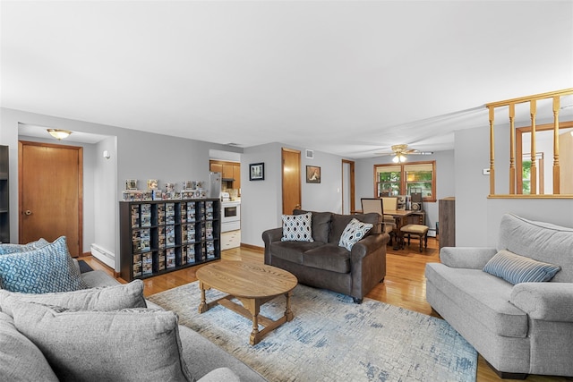 29 Chestnut St, Poughkeepsie, NY 12601 - living room with a baseboard radiator, light wood-style flooring, and a ceiling fan