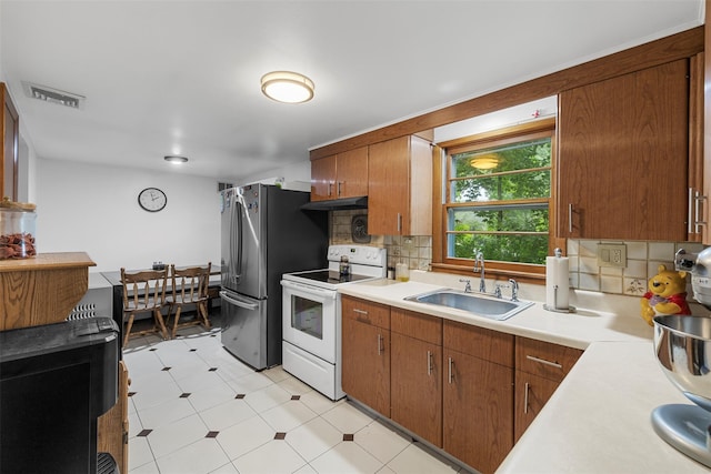 29 Chestnut St, Poughkeepsie, NY 12601 - kitchen featuring white electric stove, light countertops, tasteful backsplash, light flooring, and under cabinet range hood
